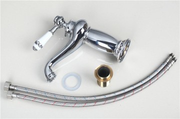 Elegante chroom kleurige wastafelkraan met witte(keramiek) elementen afgewerkt