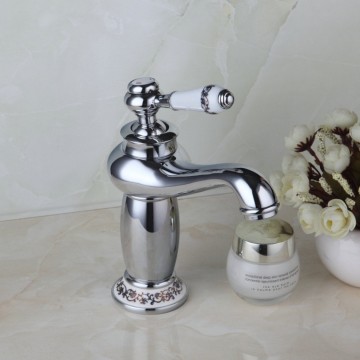 Elegante chroom kleurige wastafelkraan met witte(keramiek) elementen afgewerkt