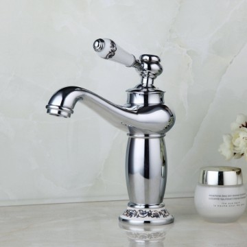 Elegante chroom kleurige wastafelkraan met witte(keramiek) elementen afgewerkt