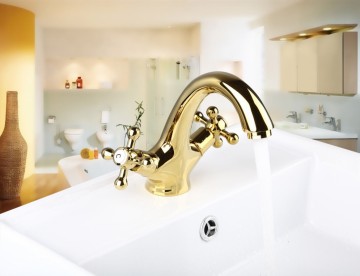 Elegante gouden wastafelkraan met witte elementen afgewerkt