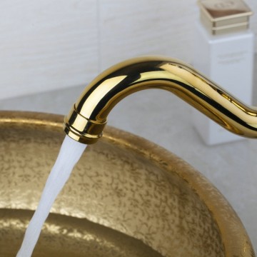 Nostalgische goudkleurige wastafelkraan met witte elementen afgewerkt draaibaar