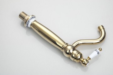 Nostalgische goudkleurige wastafelkraan met witte elementen afgewerkt draaibaar