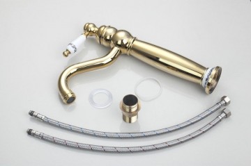 Nostalgische goudkleurige wastafelkraan met witte elementen afgewerkt draaibaar