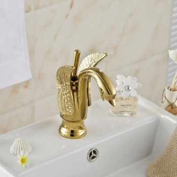 Elegante gouden wastafelkraan in de vorm van een sierlijke zwaan