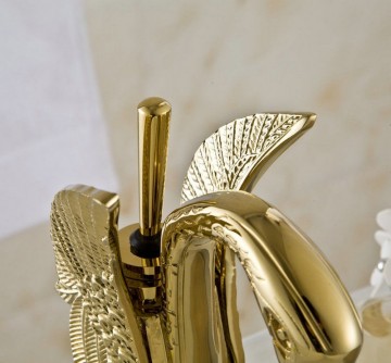 Elegante gouden wastafelkraan in de vorm van een sierlijke zwaan