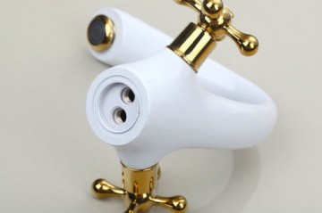 Nostalgische witte wastafelkraan met gouden elementen afgewerkt