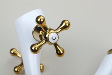 Nostalgische witte wastafelkraan met gouden elementen afgewerkt